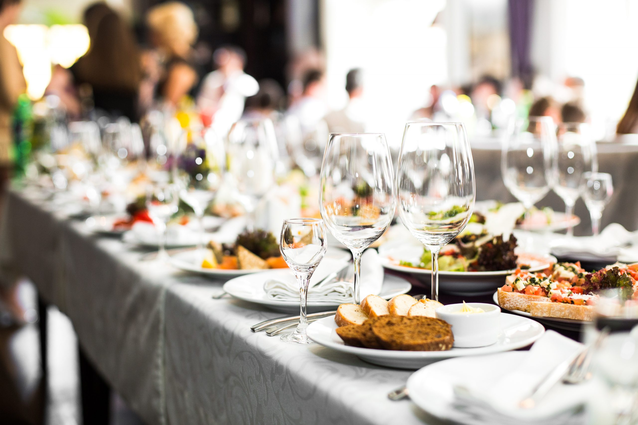 Sparkling glassware stands on long table prepared for wedding dinner